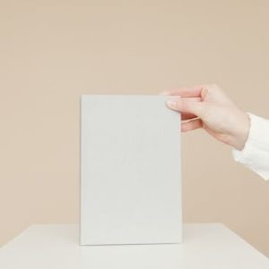 Simple minimalist image of a blank book being held by a person's hand, ideal for branding.